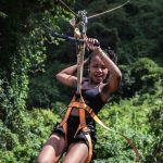 A woman on a zip line in the jungle